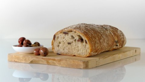 Хлеб, оливки, выпечка, разделочная доска
