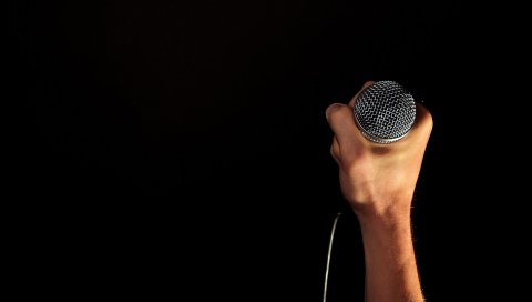 Микрофон, рука, черный фон