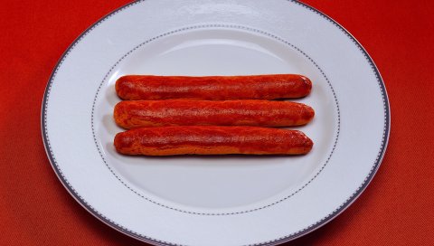 Колбасы, три, тарелка, скатерти, красный фон