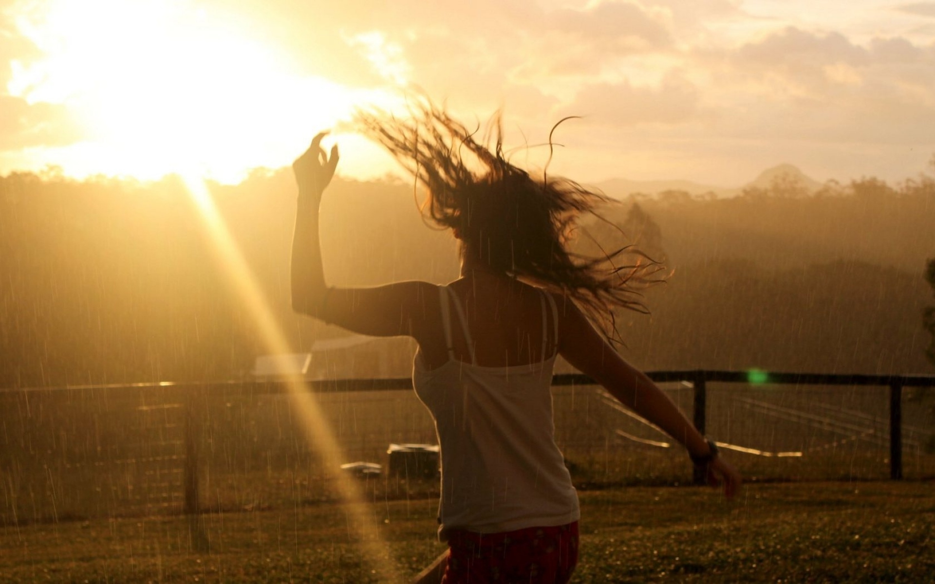 Девушка танцует в лучах солнца