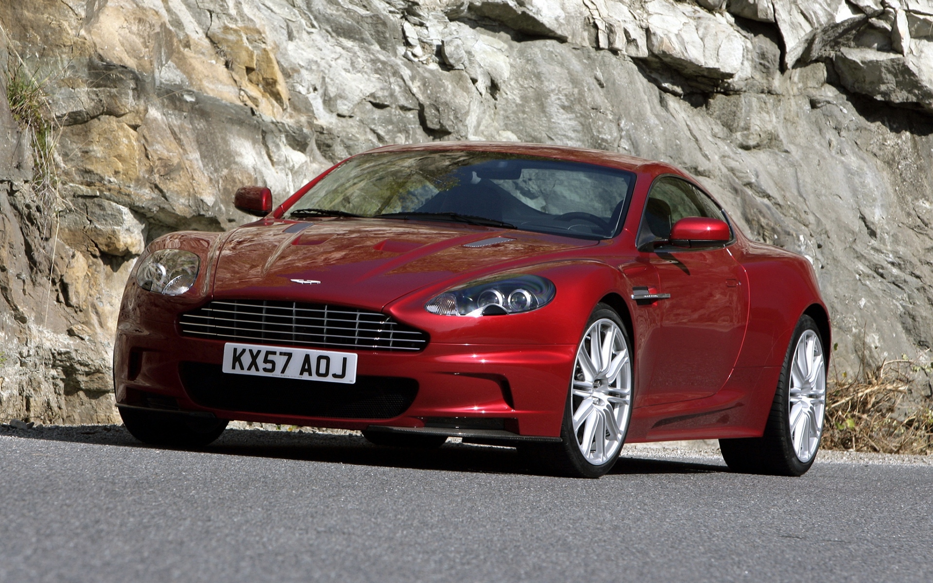 Картинки Aston martin, dbs, 2008, красный, вид спереди, камень, асфальт фото и обои на рабочий стол