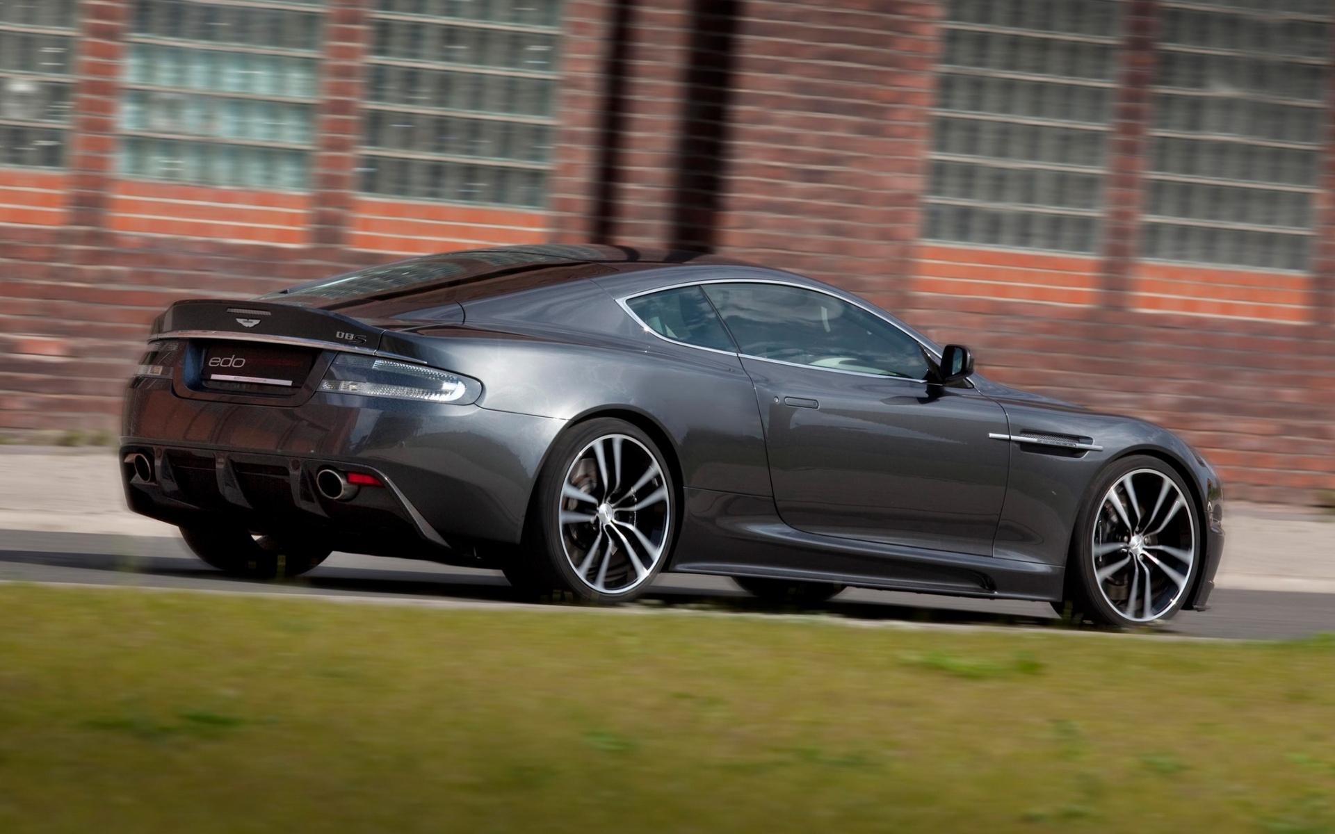 Картинки Aston martin, dbs, 2010, серый, вид сбоку, автомобили, трава, здание фото и обои на рабочий стол