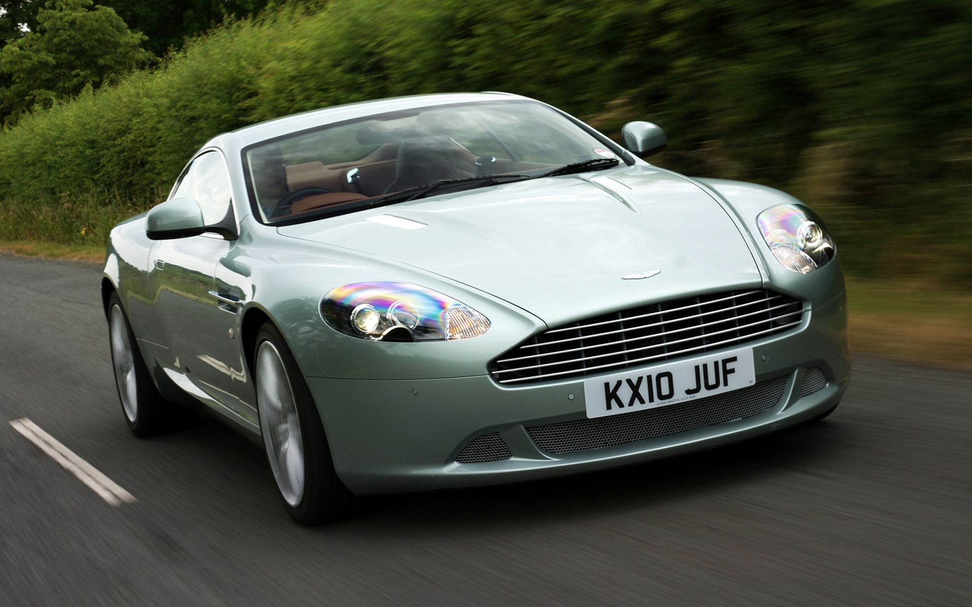 Картинки Aston martin, db9, 2010, зеленый металлик, вид спереди, стиль, спорт, автомобили, скорость, кустарники, асфальт фото и обои на рабочий стол