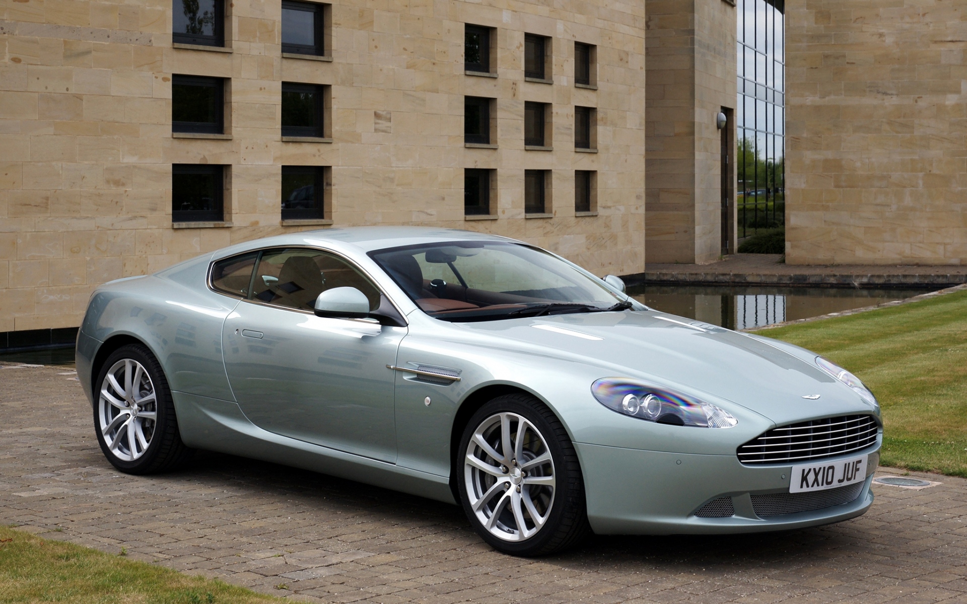 Картинки Aston martin, db9, 2010, синий металлик, вид сбоку, стиль, спорт, авто, строительство, трава фото и обои на рабочий стол